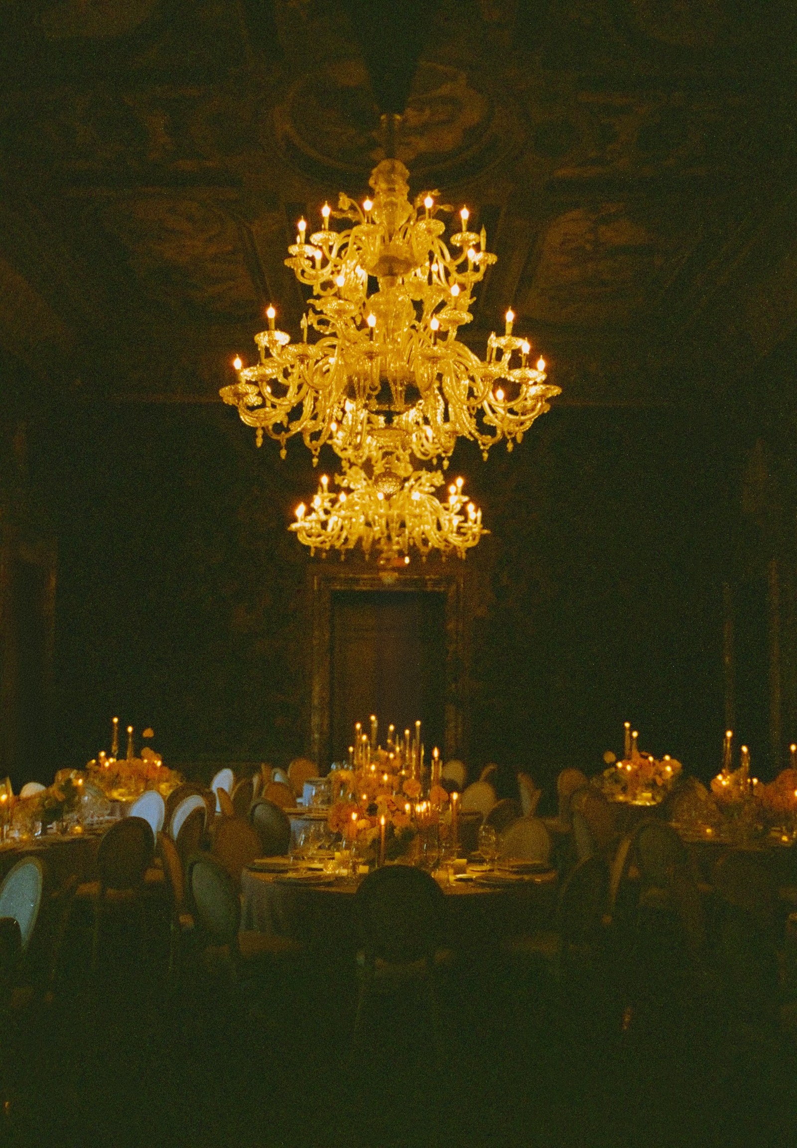 Candlelit dining room beneath chandeliers at Villa Erba