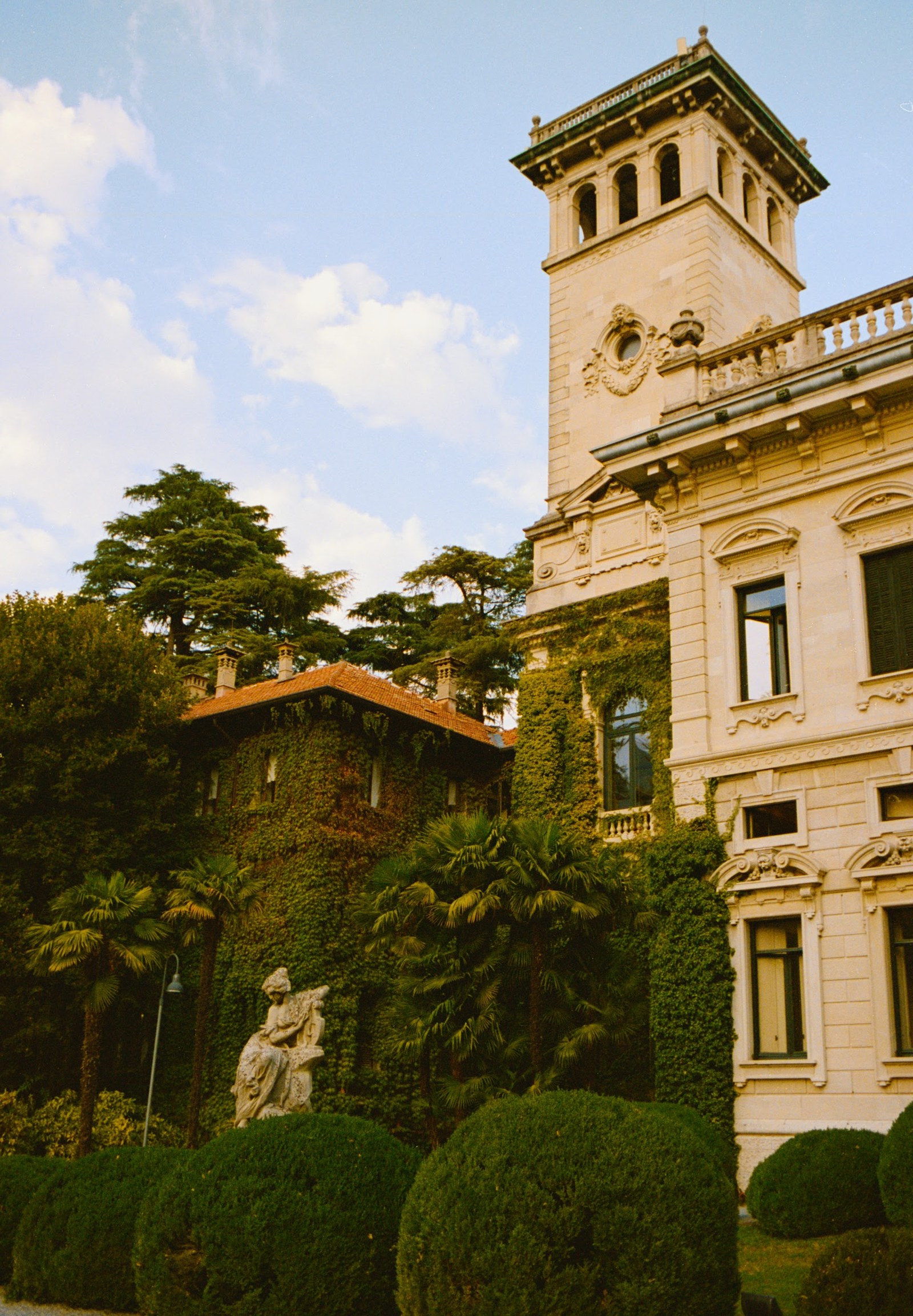 Villa Erba facade framed by clipped hedges and garden sculpture
