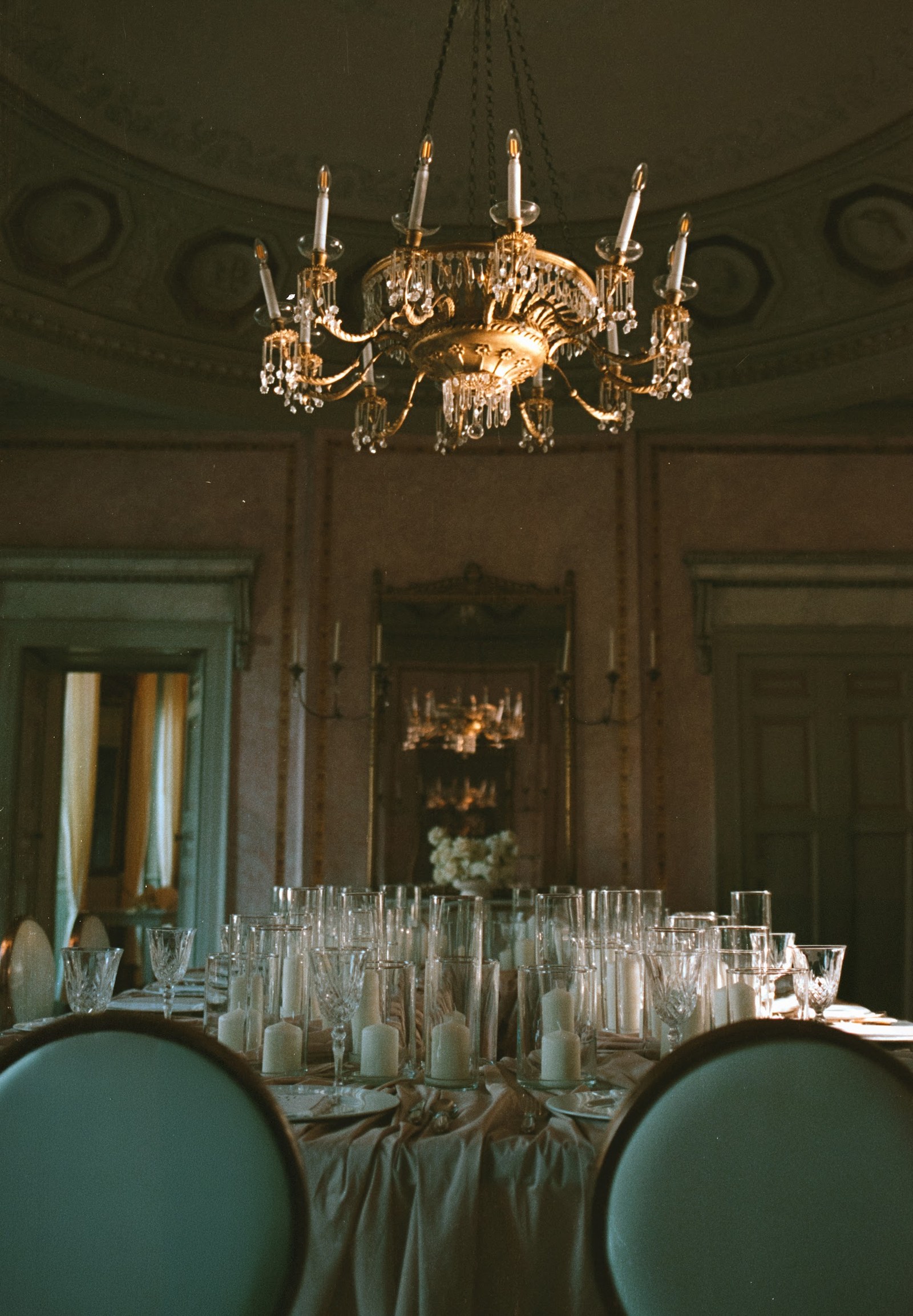 Candlelit dining table beneath a chandelier at Villa Revel Parravicini