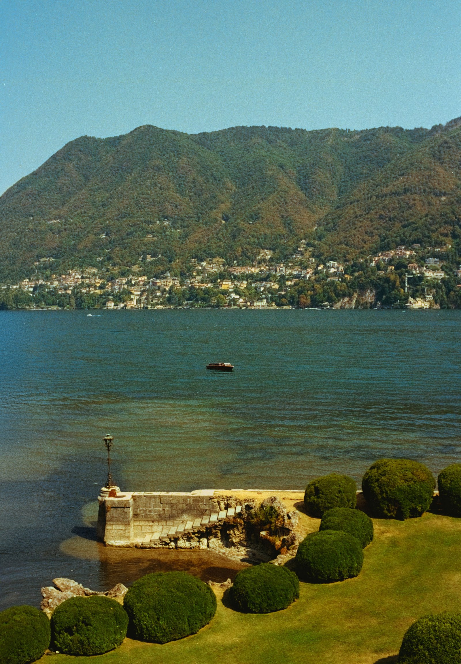 Lake view framed by garden shrubs at Villa Erba