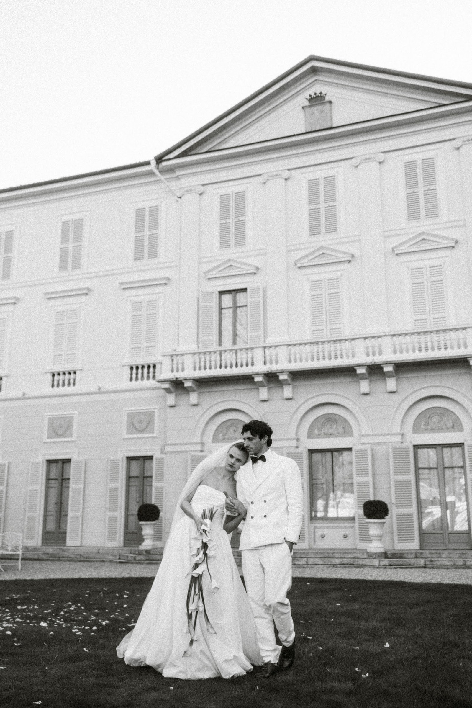 A couple walking across the lawn at Villa Revel Parravicini
